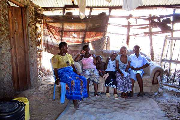 Rehema sits with some of her family in their main room.
